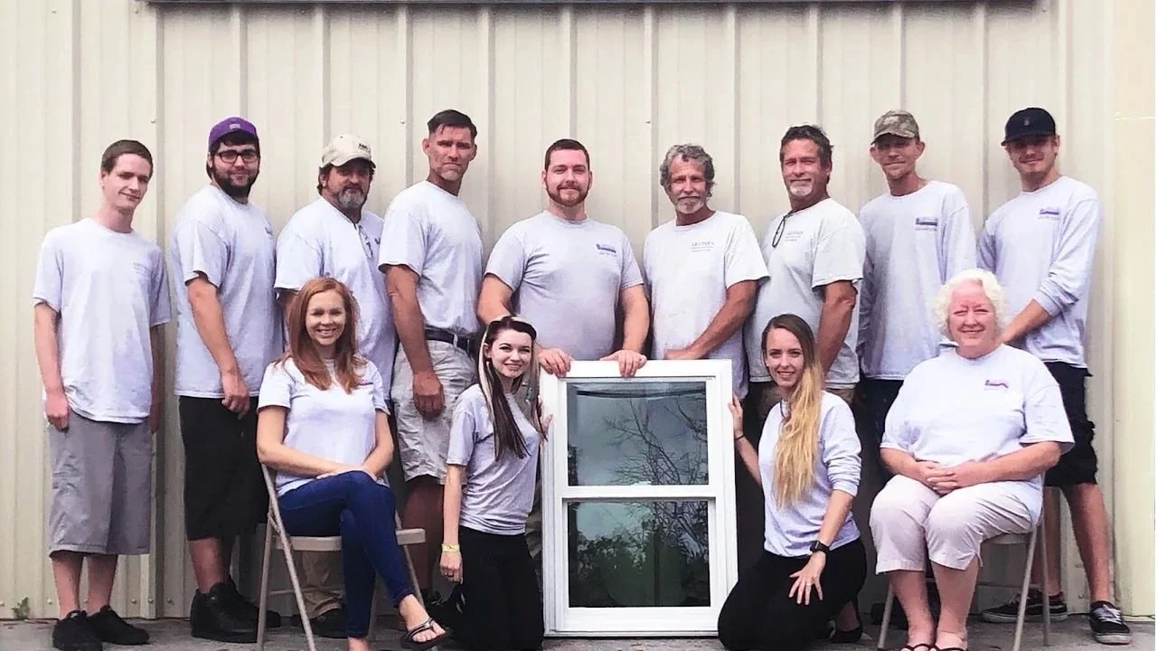 The Artisan Windows & Doors crew gathered around a replacement window